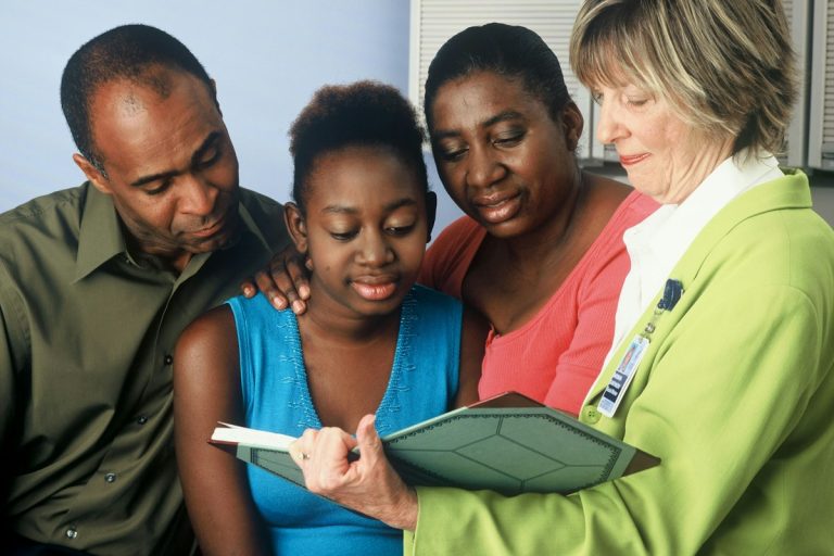 social worker assisting family healthcare enrollment application desk
