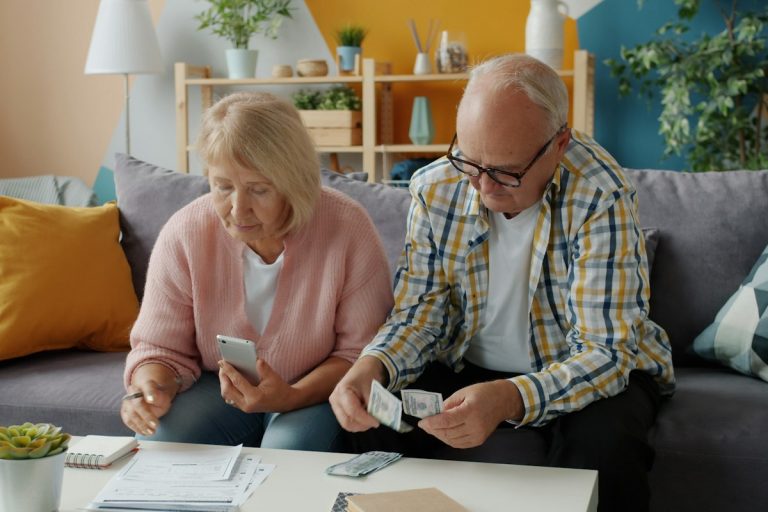 Understanding Income-Related Monthly Adjustment Amounts, Social Security Cliffs, and Medicare Surcharges senior couple reviewing financial retirement tax documents calculator advisor